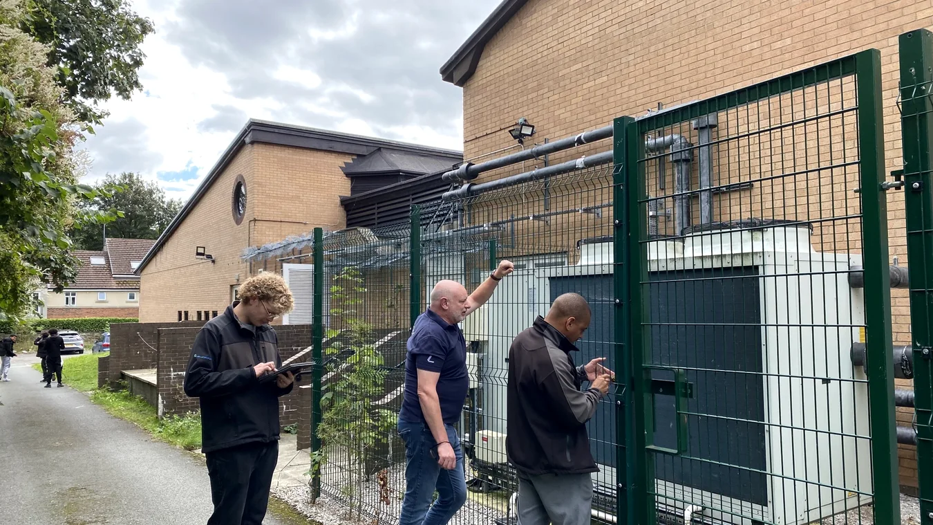 Site professionals inspecting outdoor services and equipment